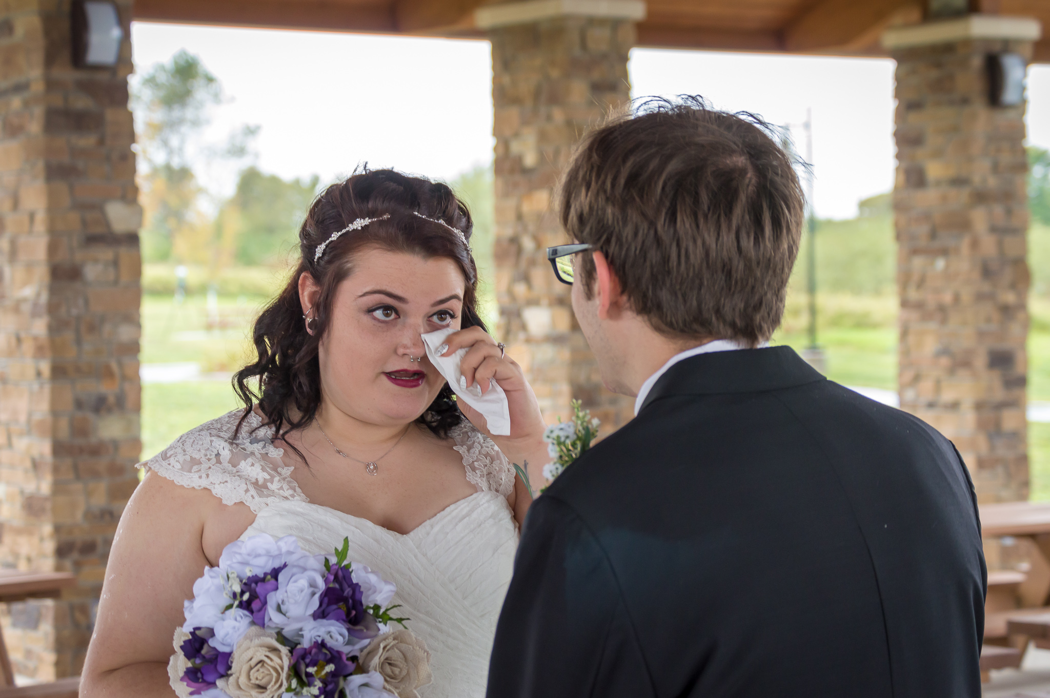 Bride wipes away a tear after seeing groom for the first look.